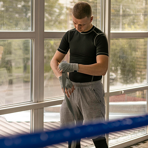 front-view-male-boxer-wrapping-his-hands-before-training-ring
